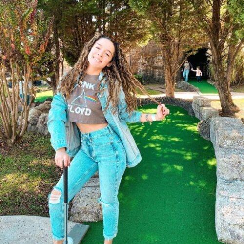 An influencer posing in the put-put course